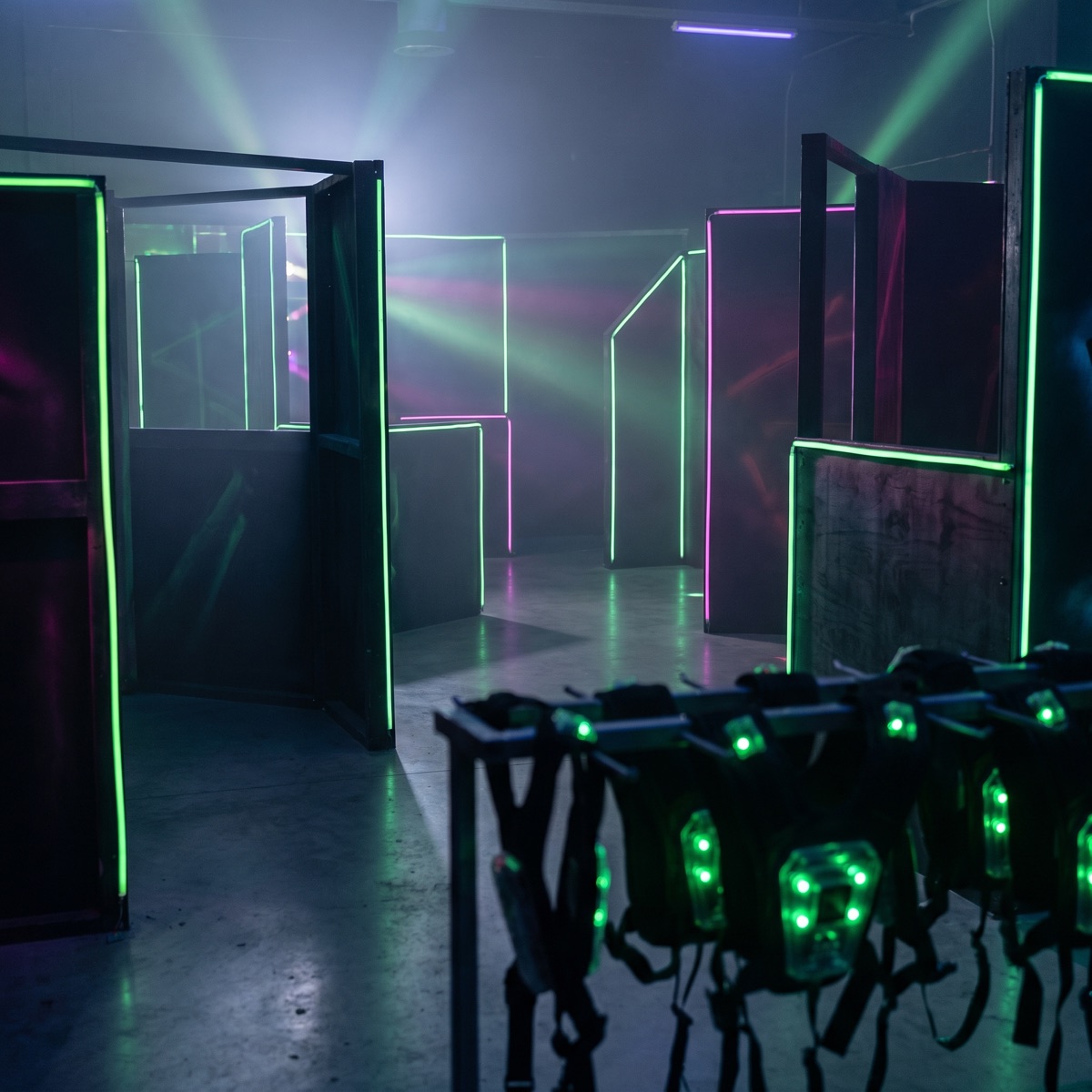Lasertag-Arena mit Neonbeleuchtung und Westen im Vordergrund